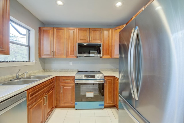 kitchen with appliances with stainless steel finishes, light tile patterned floors, and sink