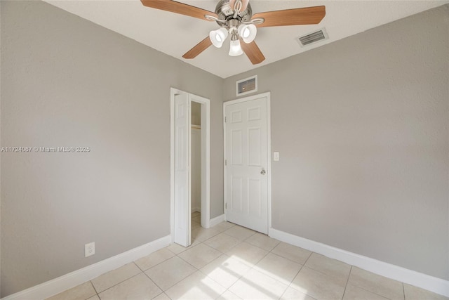 tiled empty room with ceiling fan