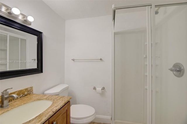 bathroom with vanity, toilet, and a shower with shower door