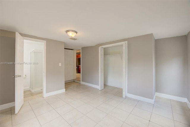 unfurnished bedroom featuring light tile patterned flooring and a closet