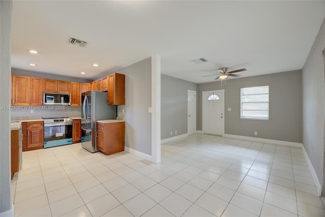 kitchen featuring stainless steel appliances, light tile patterned flooring, and ceiling fan