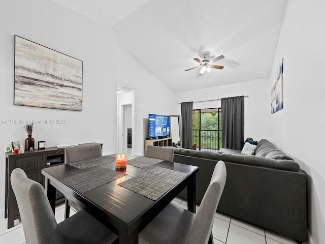 dining area with ceiling fan, light tile patterned floors, vaulted ceiling, and a textured ceiling