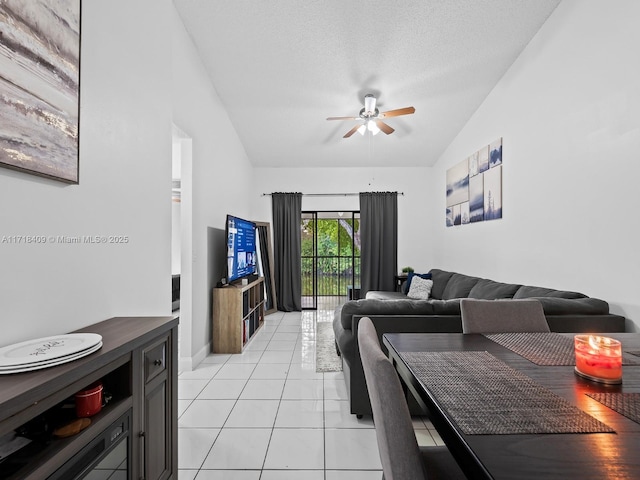 tiled living room with ceiling fan, a textured ceiling, and vaulted ceiling