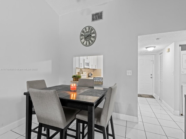 tiled dining area with a textured ceiling