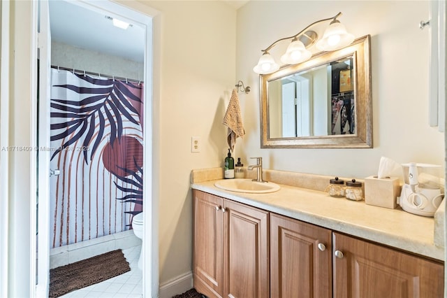 bathroom with toilet, vanity, and tile patterned flooring