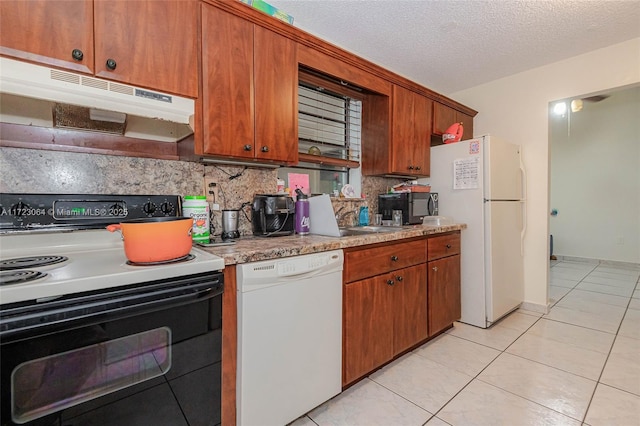 kitchen with white appliances, a textured ceiling, light tile patterned floors, and tasteful backsplash