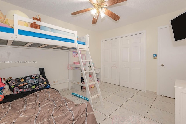 tiled bedroom with a textured ceiling, a closet, and ceiling fan