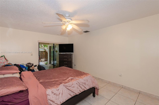 tiled bedroom with access to exterior, a textured ceiling, and ceiling fan