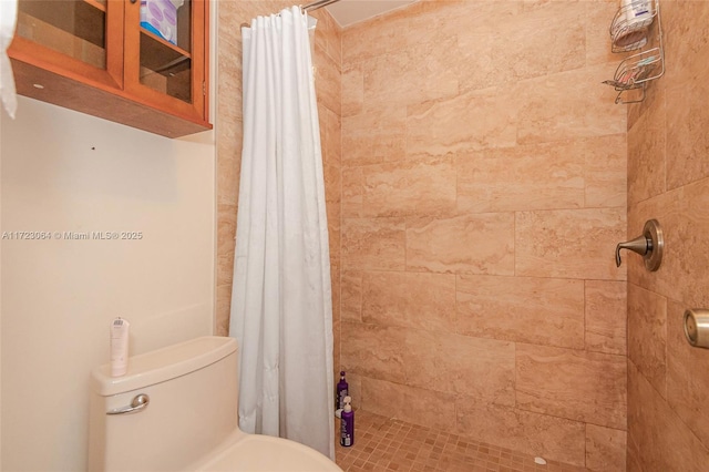 bathroom featuring toilet and a shower with shower curtain