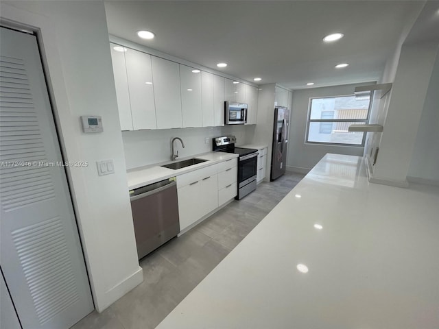 kitchen with sink, white cabinets, and appliances with stainless steel finishes