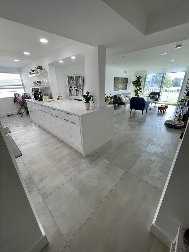 kitchen featuring kitchen peninsula and white cabinetry