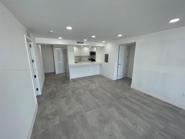 kitchen with white cabinetry, kitchen peninsula, electric panel, and stainless steel appliances