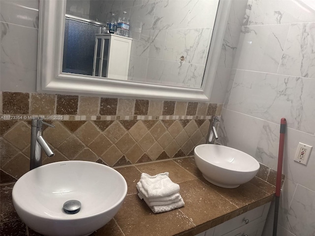 bathroom featuring sink and tile walls