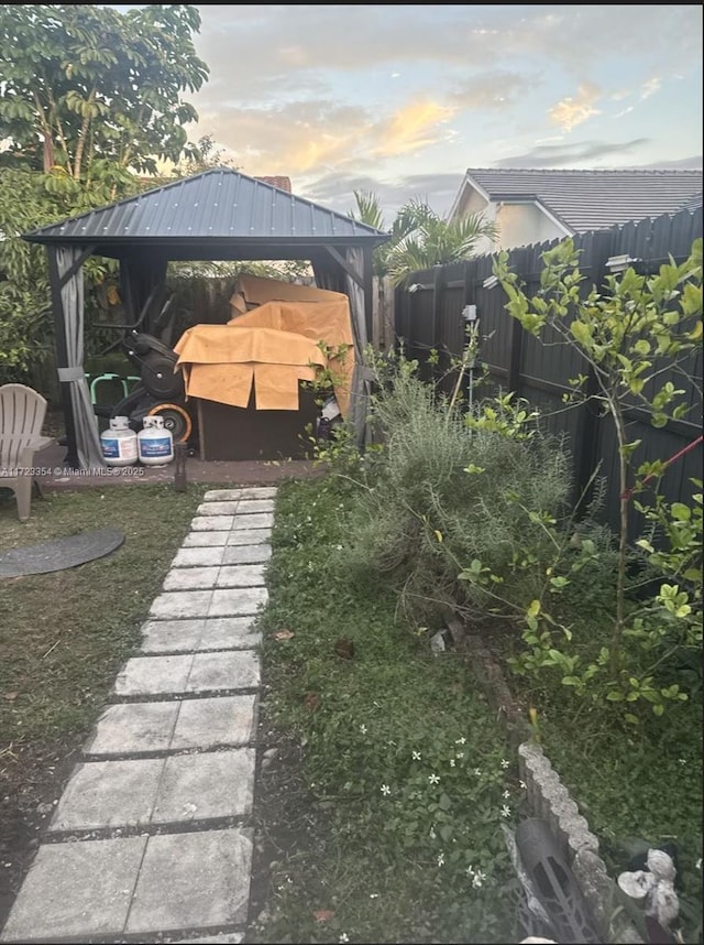 yard at dusk featuring a gazebo