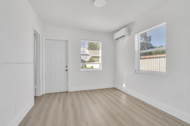 spare room featuring light hardwood / wood-style floors and an AC wall unit