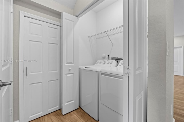 laundry area featuring light hardwood / wood-style floors and washing machine and dryer