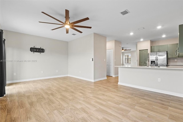 unfurnished living room featuring ceiling fan and light wood-type flooring