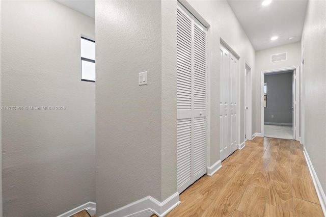 hallway with light hardwood / wood-style floors