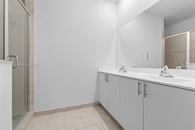 bathroom featuring tile patterned flooring, vanity, and a shower with shower door