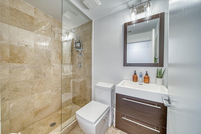 bathroom featuring a tile shower, vanity, and toilet