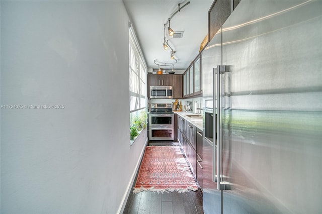 kitchen with appliances with stainless steel finishes, dark hardwood / wood-style flooring, plenty of natural light, and sink