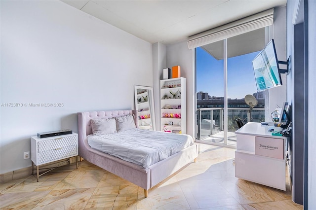 bedroom with access to outside and a wall of windows