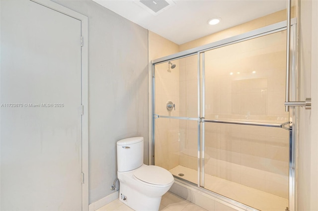 bathroom with toilet, tile patterned flooring, and walk in shower