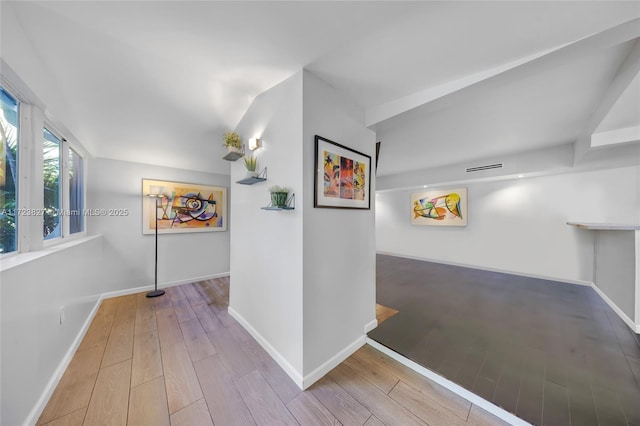hallway featuring baseboards and wood finished floors