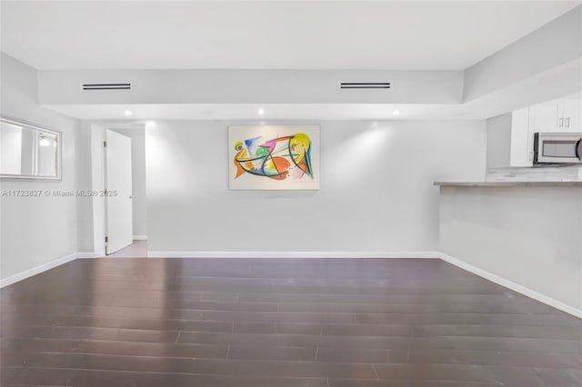interior space with visible vents, baseboards, and wood finished floors
