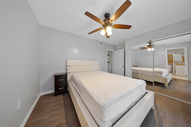 bedroom featuring baseboards, dark wood-style floors, visible vents, and ceiling fan