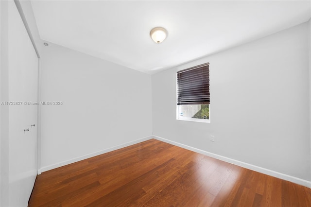 empty room with baseboards and wood finished floors