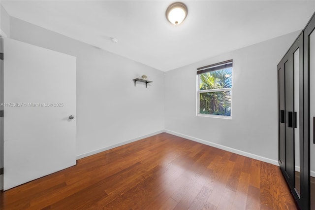 unfurnished bedroom with wood-type flooring and baseboards