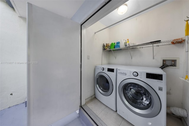 laundry area featuring light tile patterned floors, laundry area, and washer and clothes dryer