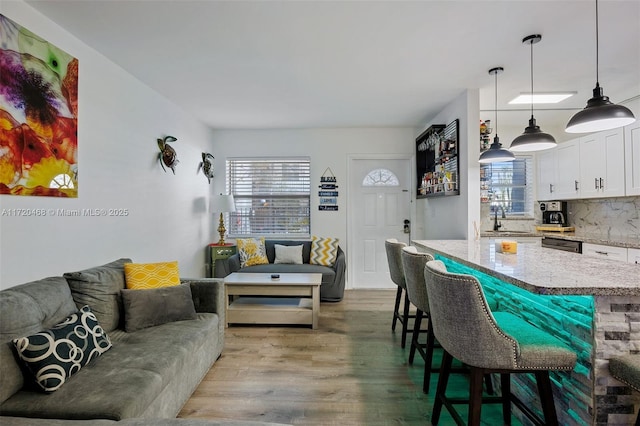 living room with sink and light wood-type flooring