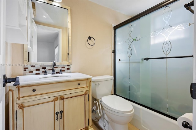 full bathroom featuring vanity, bath / shower combo with glass door, tasteful backsplash, and toilet