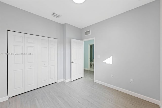 unfurnished bedroom with light hardwood / wood-style floors and a closet