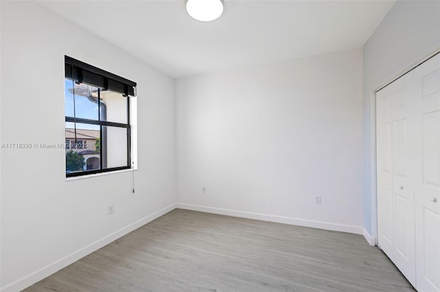 unfurnished bedroom featuring light wood-type flooring and a closet