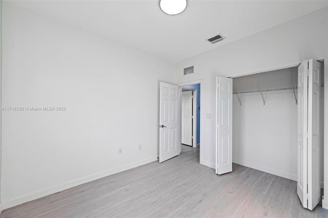 unfurnished bedroom featuring light wood-type flooring and a closet