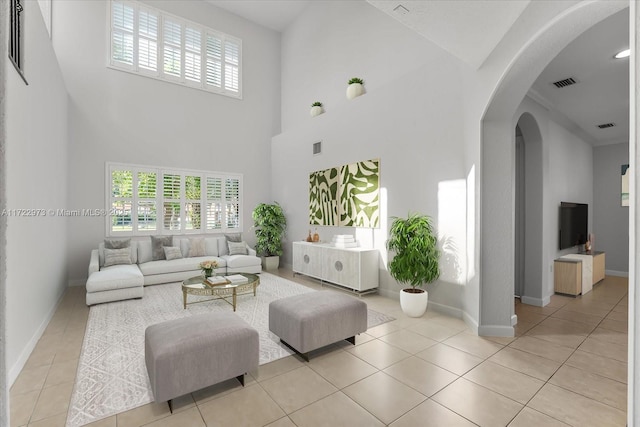 tiled living room featuring a towering ceiling