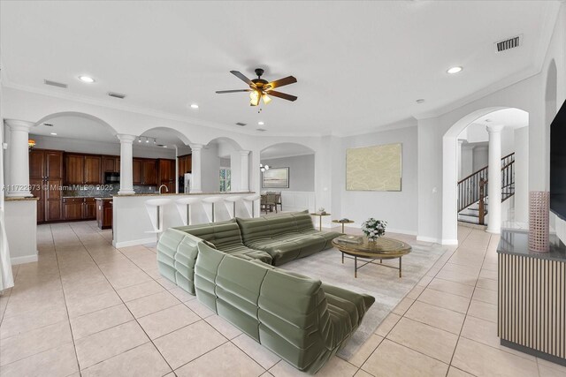 tiled living room featuring crown molding and ceiling fan