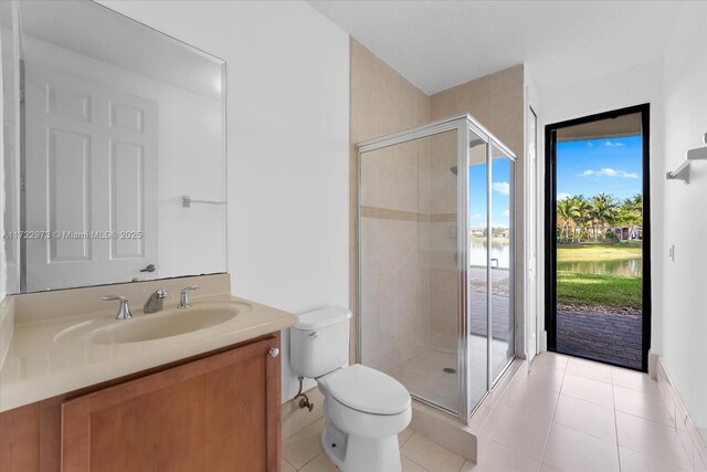 bathroom featuring tile patterned floors, vanity, toilet, and walk in shower