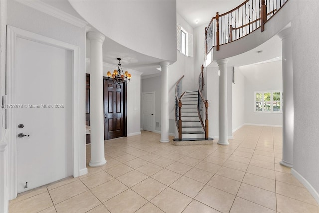 tiled foyer entrance featuring a notable chandelier, ornamental molding, and a high ceiling