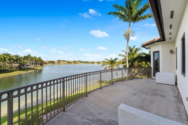 view of patio featuring a balcony and a water view