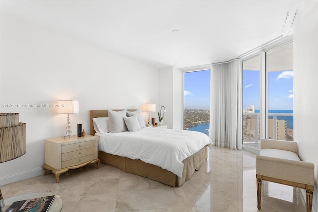 bedroom featuring a water view and a wall of windows