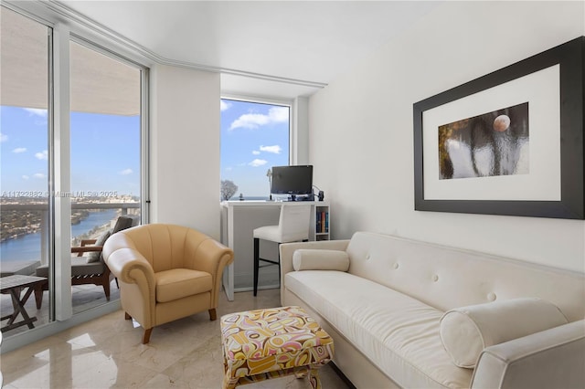 sitting room featuring expansive windows and a water view