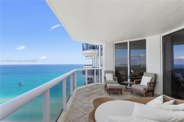 balcony with an outdoor living space and a water view