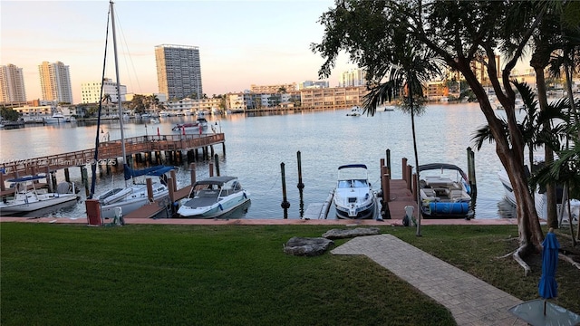 dock area with a lawn, a water view, and a city view