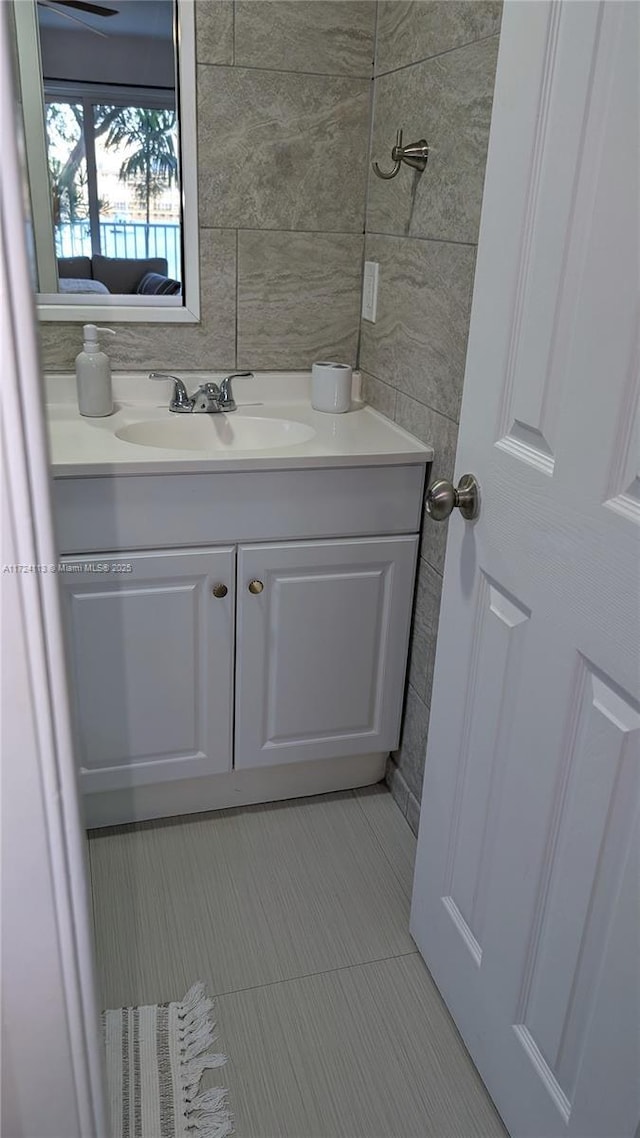 bathroom featuring tile patterned floors, vanity, and tile walls