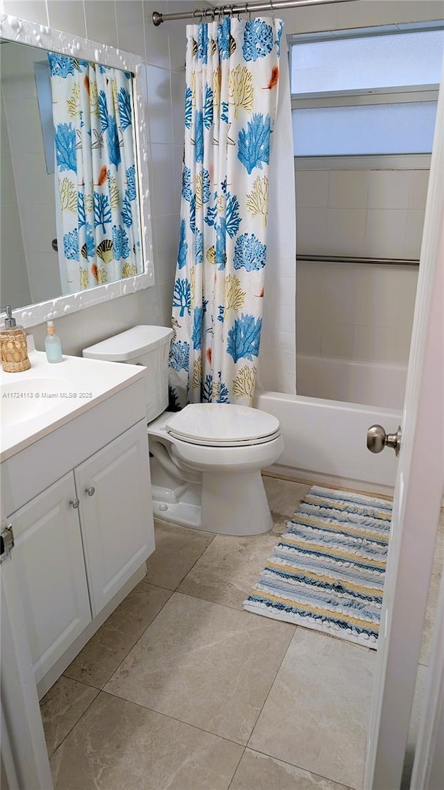 full bathroom with tile patterned floors, shower / bath combo, toilet, and vanity