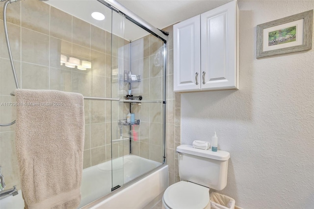 bathroom with toilet and bath / shower combo with glass door